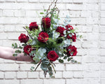 Beautiful long stemmed red roses mixed with green foliage