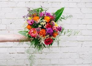 A colourful bouquet with dark pinks and orange flowers
