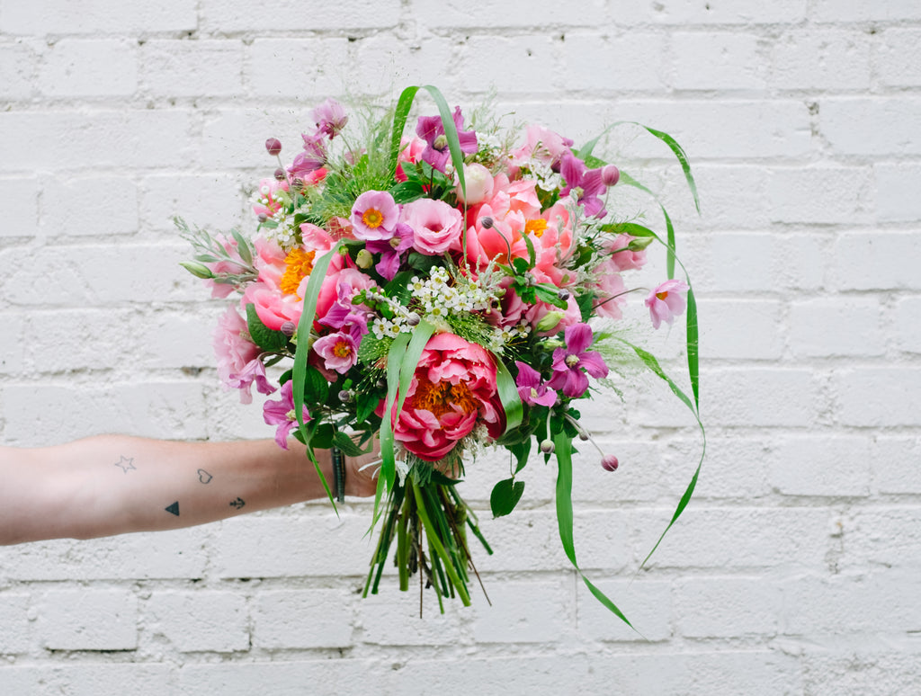 A hand tied bouquet of pink seasonal flowers